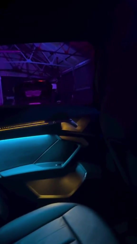Door card lit cyan with a warm footwell glow below