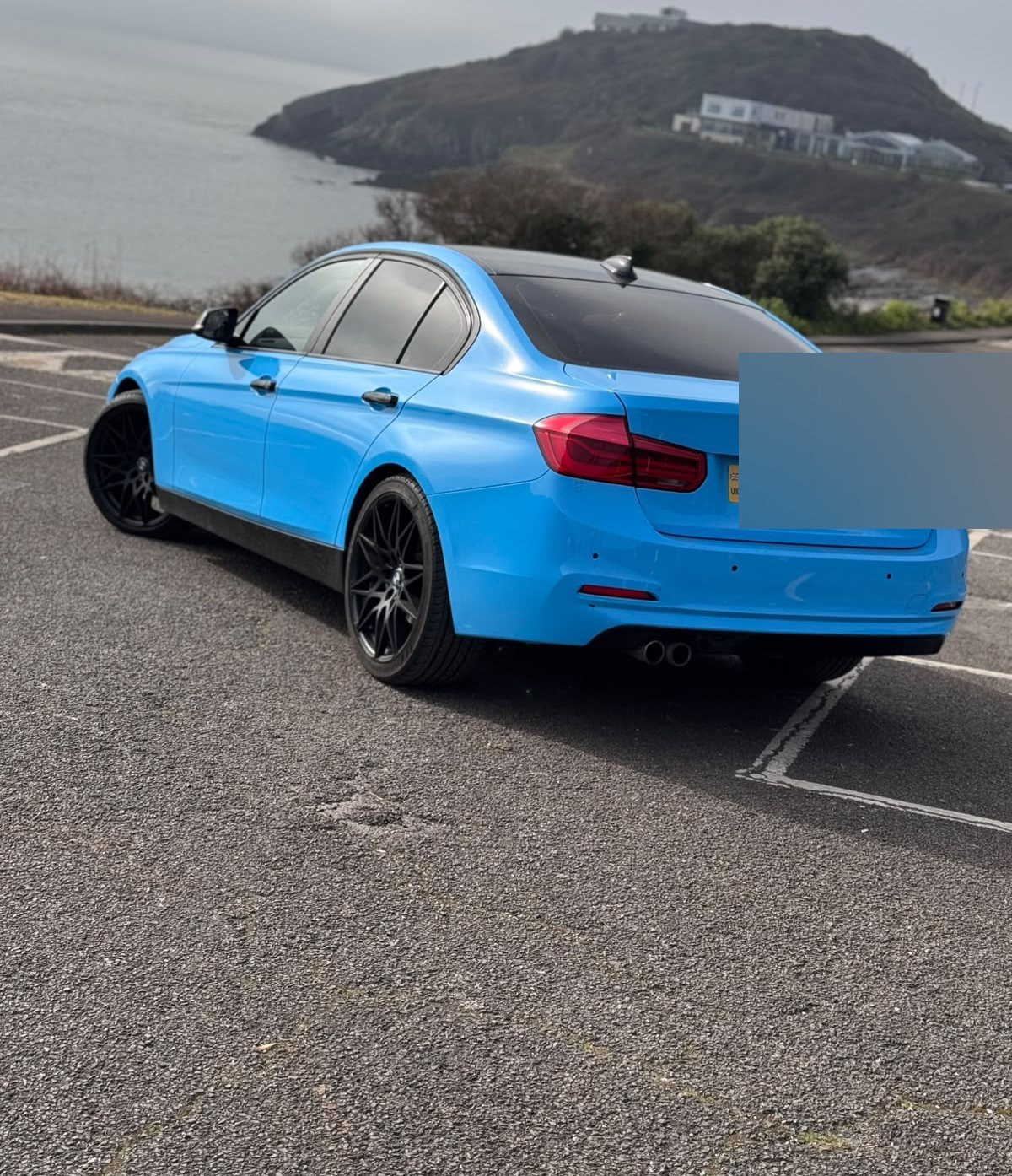 Rear three-quarter of the gloss blue BMW 3 Series with tinted glass